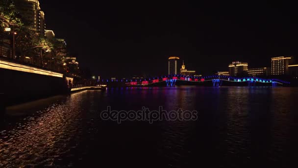 Iluminación nocturna del nuevo puente peatonal Rainbow a través del vídeo de archivo del río Sanya — Vídeos de Stock