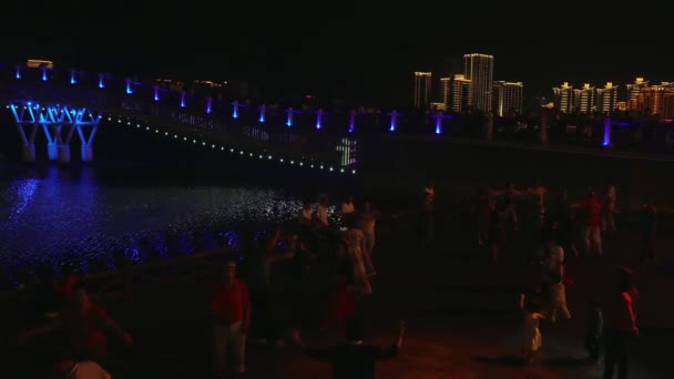 Bailes nocturnos de chinos y turistas en el terraplén del video de archivo del río Sanya — Vídeo de stock