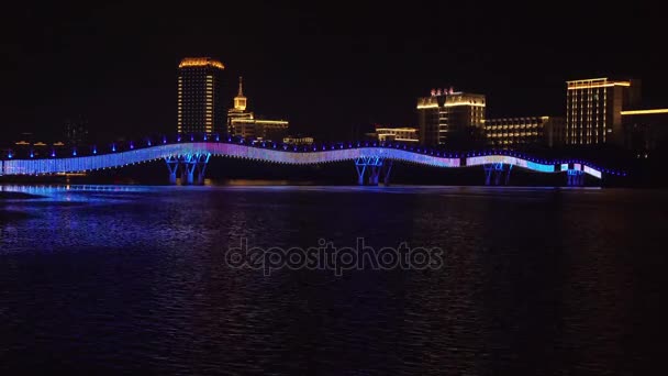 Iluminação noturna da nova ponte pedonal Arco-íris através do Rio Sanya time lapse imagens de vídeo — Vídeo de Stock