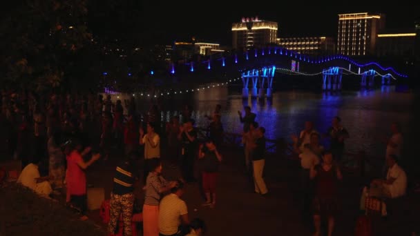中国語と三亜川ビデオ映像素材の堤防で観光客の夜のダンス — ストック動画