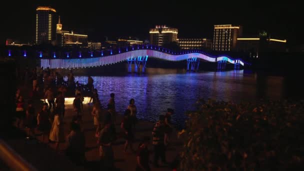 Danças noturnas de chineses e turistas no dique do Rio Sanya — Vídeo de Stock