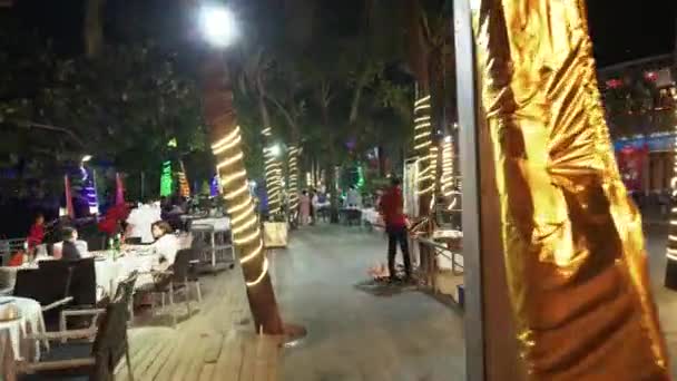 Walking on a night tourist promenade with restaurants on Dadonghai beach time lapse stock footage video — Stock Video