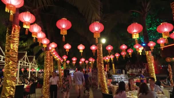 Lopen op een nacht toeristische boulevard met restaurants op Dadonghai beach stock footage video — Stockvideo