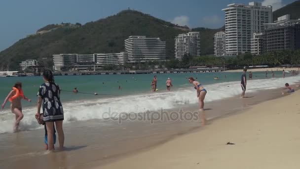 Turisté koupat v silných vlnách Jihočínského moře na pláži Dadonghai stopáže videa — Stock video