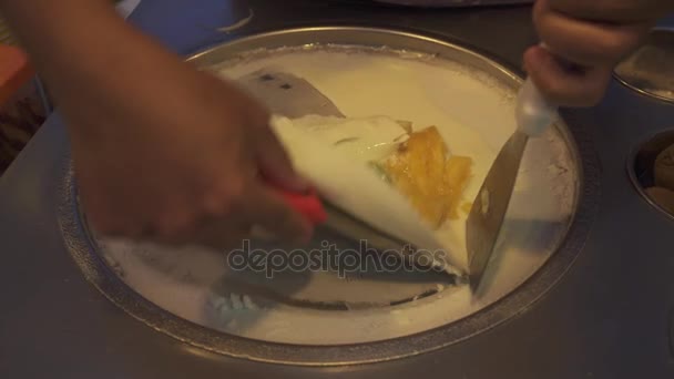 Процесс приготовления вкусного тайского натурального мороженого с фруктами на специальном оборудовании на фестивале открытых продуктов питания — стоковое видео