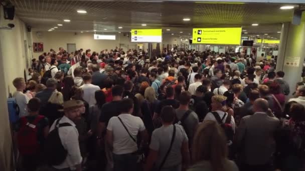 Une foule énorme de personnes dans la zone des arrivées attendent une file d'attente dans le contrôle des passeports à l'aéroport international de Sheremetyevo — Video