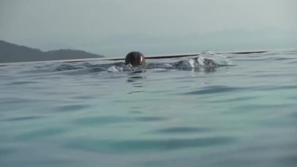 Chica joven nada en la piscina al aire libre material de archivo de vídeo — Vídeo de stock