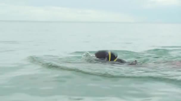 Jovem em óculos de esportes está flutuando no mar imagens de vídeo — Vídeo de Stock