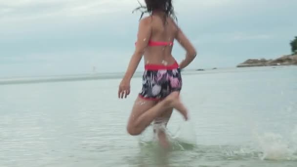 Alegre feliz joven corriendo en agua mar spray cámara lenta archivo de vídeo — Vídeos de Stock