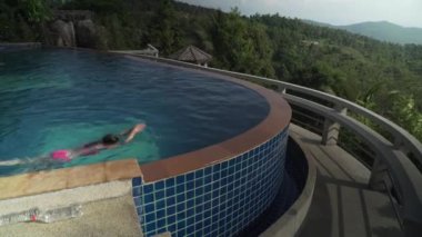 Genç kız bir dağ stok görüntüleri video üstüne havuzunda yüzüyor