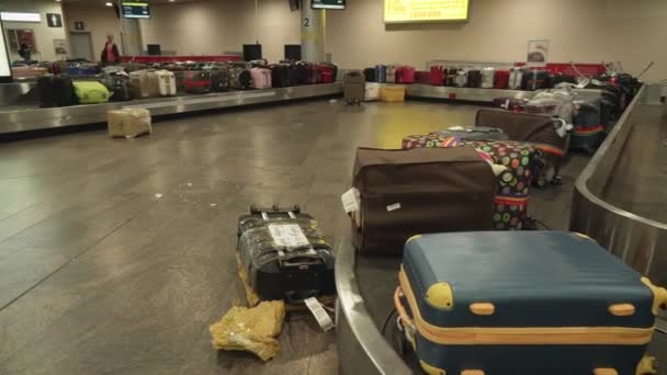 Malas na área de reclamação de bagagem estão esperando os proprietários que estão presos na fila no controle de passaporte no Aeroporto Internacional de Sheremetyevo. estoque de imagens de vídeo — Vídeo de Stock