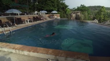 Genç kız Paradise Park Farm Samui stok görüntüleri video bir dağın tepesine havuzunda yüzüyor