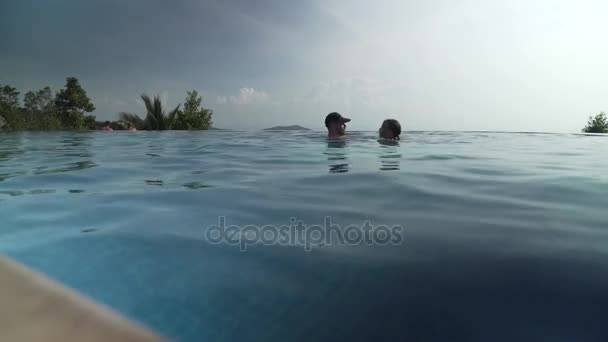 Chica joven con papá nadando en la piscina al aire libre material de archivo de vídeo — Vídeos de Stock