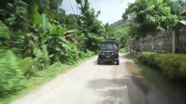 Внедорожник едет по дороге среди джунглей Ко Самуи (Koh Samui) в Таиланде — стоковое видео