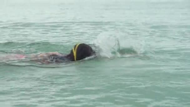 Młoda dziewczyna w okulary sportowe jest pływające w morzu Stockowy wideo — Wideo stockowe