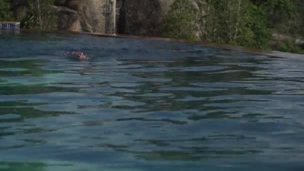 Fiatal lány az úszás a medencében a tetején egy hegy stock footage videóinak — Stock videók