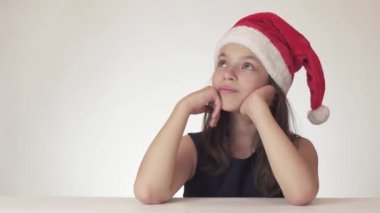 Bir hediye, bir Noel Baba şapka rüyalarda güzel mutlu genç kız ve beyaz arka plan üzerinde hisse senedi görüntüleri alır uzun zamandır beklenen köpek video