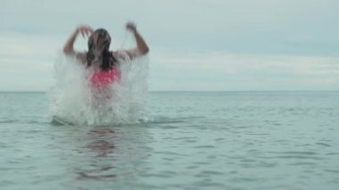 Neşeli mutlu genç kız deniz yavaş hareket hisse senedi görüntüleri video su sıçramasına ile oynamak