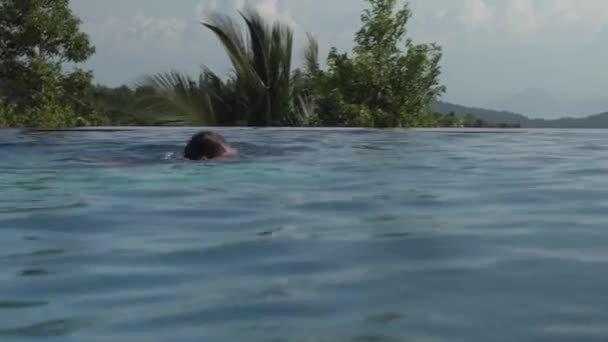 Chica joven nada en la piscina al aire libre material de archivo de vídeo — Vídeo de stock