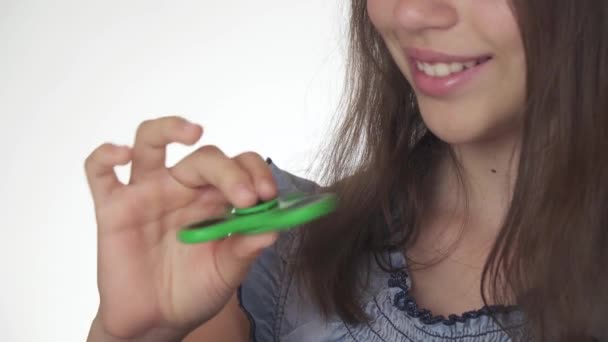 Piękny wesoły teen dziewczyna bawi się z pokrętła zielony fidget na białym tle Stockowy wideo — Wideo stockowe
