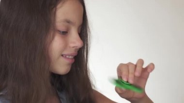 Beyaz arka plan stok görüntüleri video üzerinde yeşil topluca spinner ile oynarken güzel neşeli genç kız
