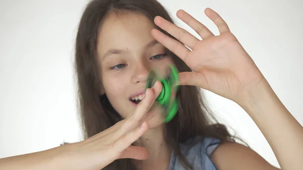 Belle gai adolescent fille jouer avec vert fidget spinner sur fond blanc — Photo