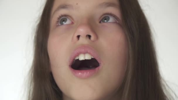 Ευτυχισμένο το όμορφο κορίτσι εφηβική είναι έκπληκτος γκρο πλαν σε λευκό φόντο πλάνα βίντεο — Αρχείο Βίντεο