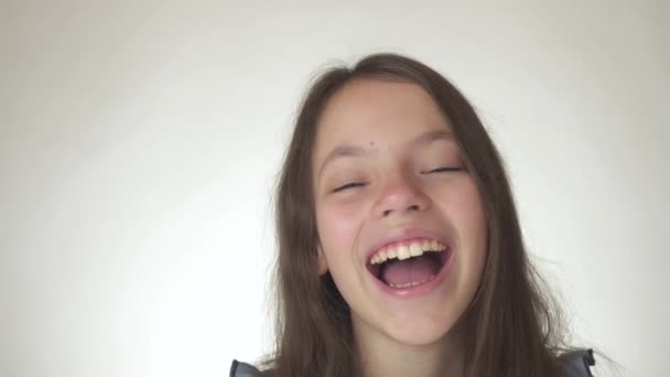 Hermosa chica adolescente feliz riendo de cerca en el fondo blanco material de archivo de vídeo — Vídeos de Stock