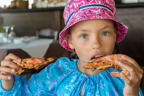 Turistické dívka jí velké krevety v kavárně na poloostrově Sithonia — Stock fotografie