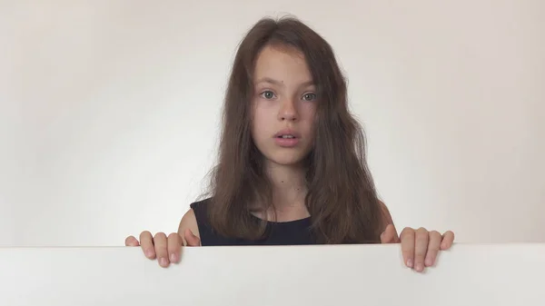 Vacker flicka Tonåring håller en affisch med information och är förvånad på vit bakgrund — Stockfoto