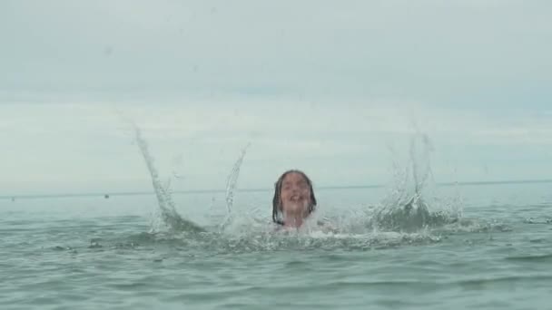 Alegre feliz joven jugando con salpicaduras de agua en el mar cámara lenta material de archivo de vídeo — Vídeos de Stock