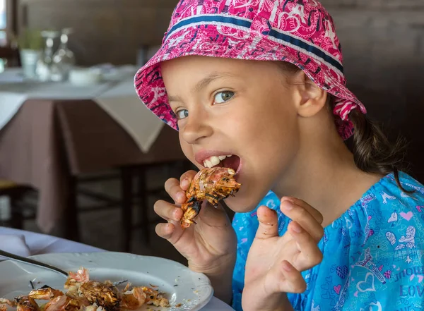 Tourist girl eats large shrimp in cafe on the Sithonia peninsula — Stock Photo, Image