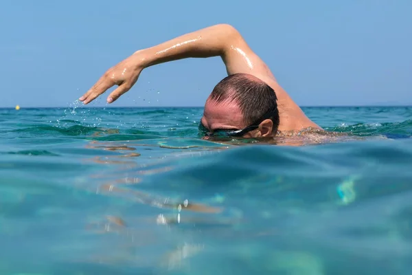 水泳のスポーツ グラスで観光男が海岸のシトニア半島のエーゲ海に浮かんでいます。 — ストック写真