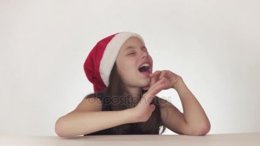 Güzel mutlu kız genç bir Noel Baba şapkalı duygusal beyaz arka plan stok görüntüleri video şarkı söylüyor.