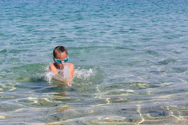 年轻的旅游女孩游泳运动眼镜是漂浮在爱琴海的 Sithonia 半岛海岸 — 图库照片