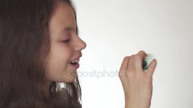 Beyaz arka plan stok görüntüleri video üzerinde yeşil topluca spinner ile oynarken güzel neşeli genç kız