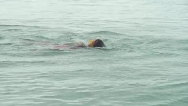 Junges Mädchen mit Sportbrille schwimmt im Meer — Stockvideo