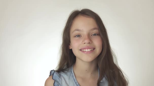 Bela menina adolescente feliz sorrindo close-up no fundo branco imagens de vídeo — Vídeo de Stock