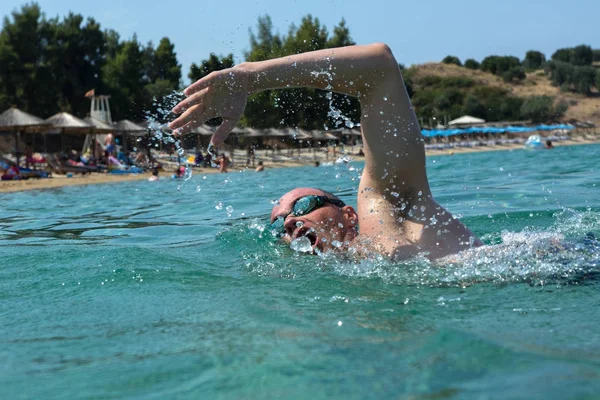 Uomo turistico in occhiali da bagno sportivo galleggia nel Mar Egeo sulla costa della penisola di Sithonia — Foto Stock