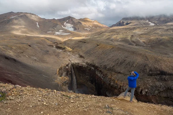 관광은 Mutnovsky 캄차카에서 화산 근처 위험한 협곡에 폭포의 사진을 찍고는. — 스톡 사진