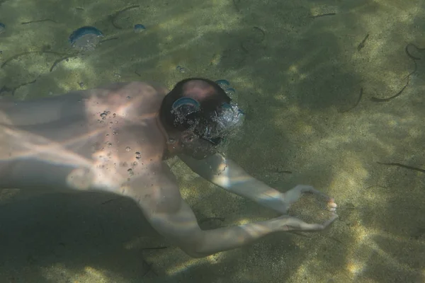 Turisztikai férfi sport szemüveg az Égei-tenger a tengerparton a Sithonia-félszigeten víz alatti úszás úszás — Stock Fotó