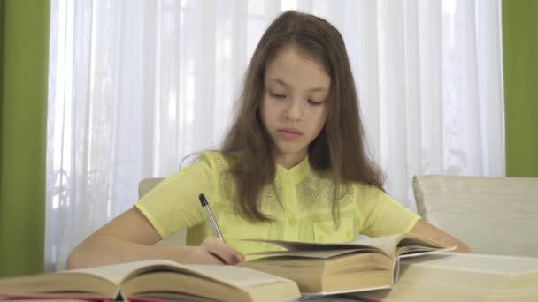 Adolescente chica hace la tarea en la tabla de archivo de vídeo — Vídeos de Stock