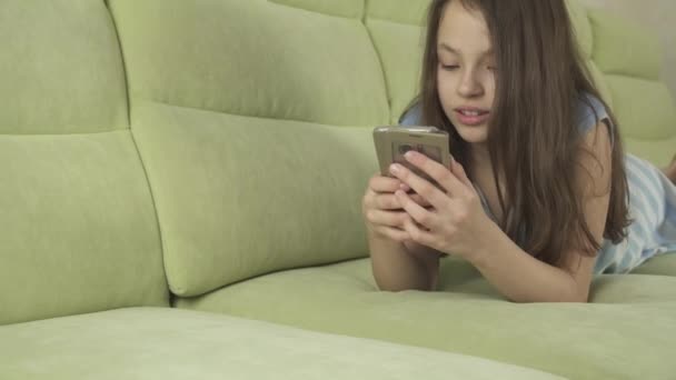 Belle adolescente s'amuser à communiquer sur smartphone stock vidéo — Video