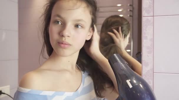 Szép tini lány kiszárad a haj egy hajszárító, fürdőszoba stock footage videó — Stock videók