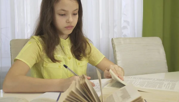 Tonåring flicka gör läxor vid bord — Stockfoto