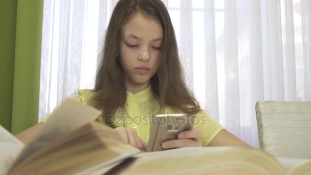 Adolescente menina faz lição de casa com vídeo de imagens de estoque de smartphones — Vídeo de Stock