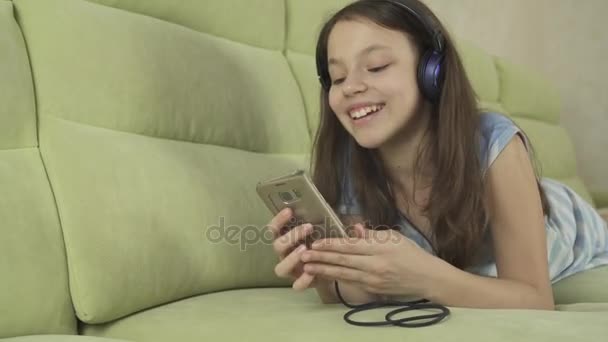 Belle adolescente dans des écouteurs chantant des chansons de karaoké sur smartphone stock footage video — Video