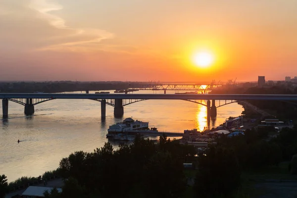 Krásný západ slunce nad Octyabrsky mostu přes řeku Ob v Novosibirsk — Stock fotografie