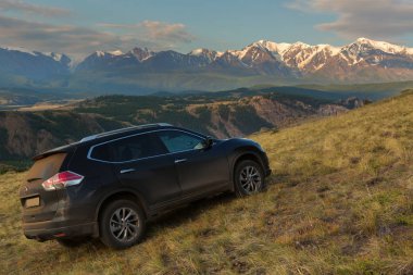 Crossover Nissan X-Trail Kurai bozkır şafak Kuzey Chuy Ridge'te zemin karşı yamaca.