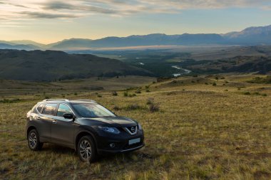 Crossover Nissan X-Trail Kurai bozkır şafak Kuzey Chuy Ridge'te zemin karşı yamaca.